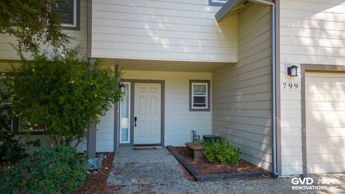Updated home exterior featuring James Hardie siding in light beige, with a welcoming front door and landscaping in Sacramento