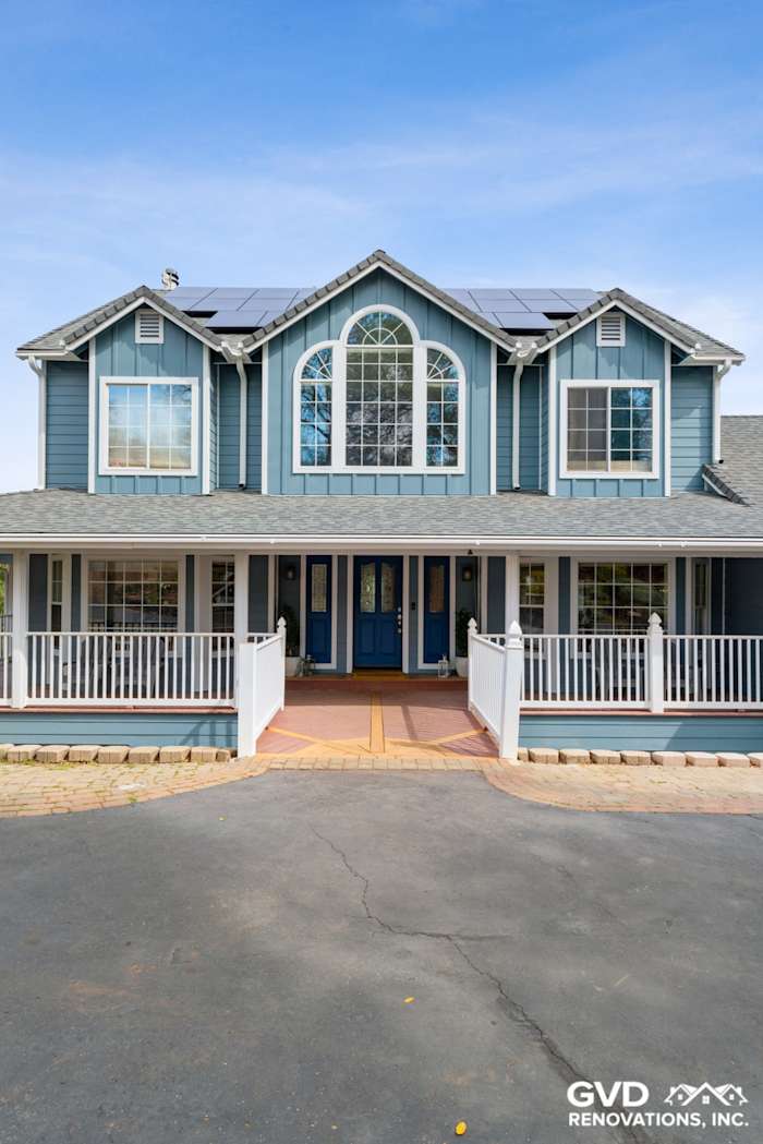 Two-story home in Shingle Springs with new blue James Hardie siding, front porch, and solar panels