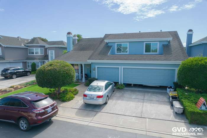 Transformed home exterior in Foster City with James Hardie siding and Alside windows, featuring blue trim and manicured
