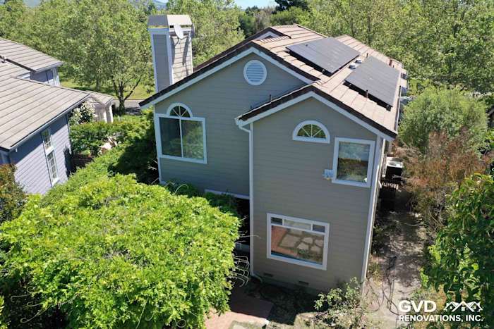 Two-story home exterior featuring Monterey Taupe James Hardie siding and Arctic White trim, surrounded by greenery