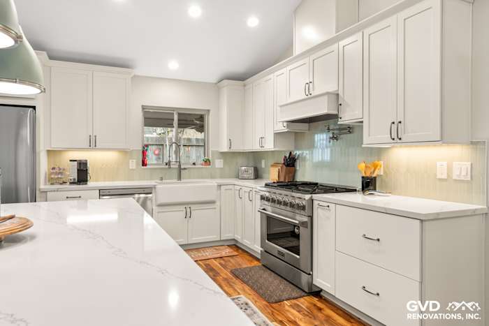 Bright kitchen with white cabinets, a large island, and marble countertops in Carmichael, CA remodel
