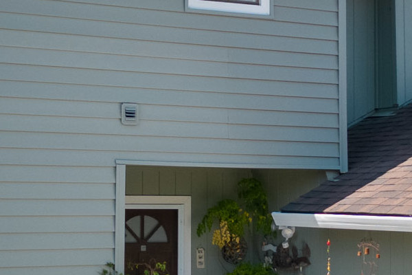 New Alside Prodigy vinyl siding in light gray on a two-story home with Mezzo windows in El Sobrante