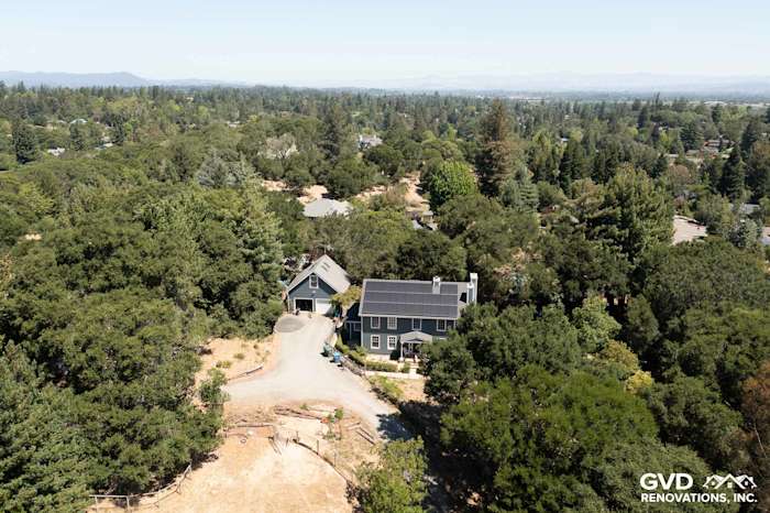 Aerial view of a home with Evening Blue James Hardie siding and Arctic White trim surrounded by trees in Sebastopol