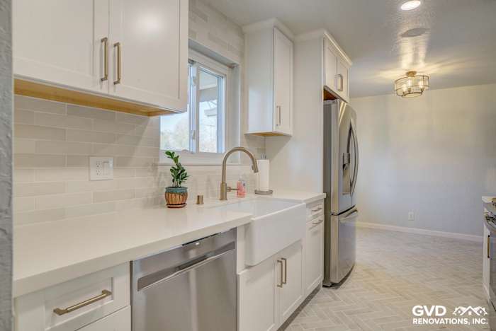Modern kitchen featuring a farmhouse sink, white cabinetry, quartz countertops, and brushed nickel fixtures in Fair Oaks