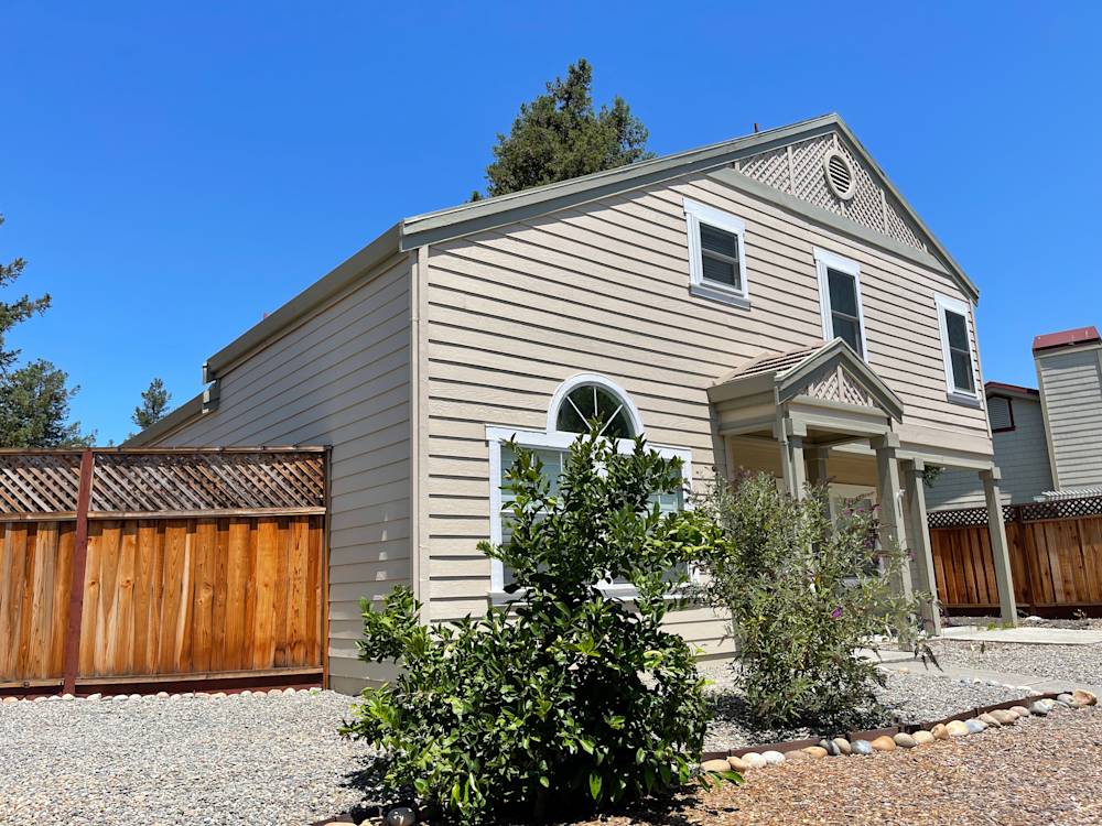 Exterior view of a Sacramento home with beige siding, decorative trim, and landscaped gravel yard