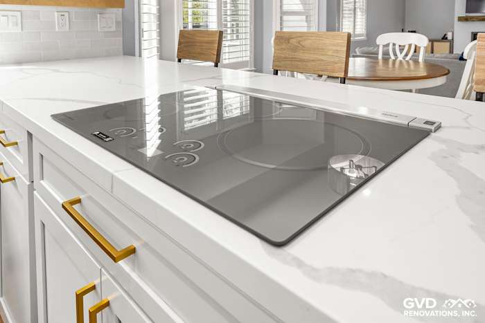 Modern kitchen island featuring a sleek quartz countertop and a built-in induction cooktop in El Dorado Hills