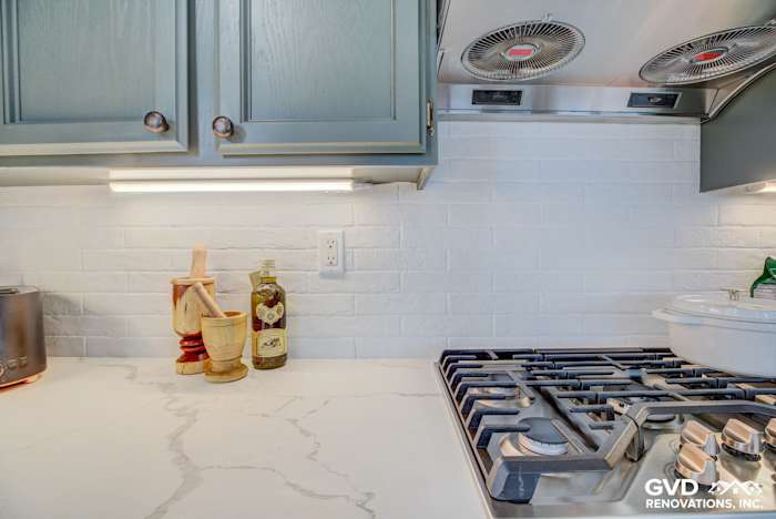 Marble countertop with gray cabinetry, stainless steel appliances, and white subway tile backsplash in El Dorado Hills