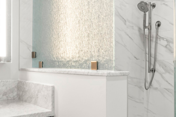 Modern bathroom remodel in Carmichael featuring a blue vanity, glass shower enclosure, and marble accents