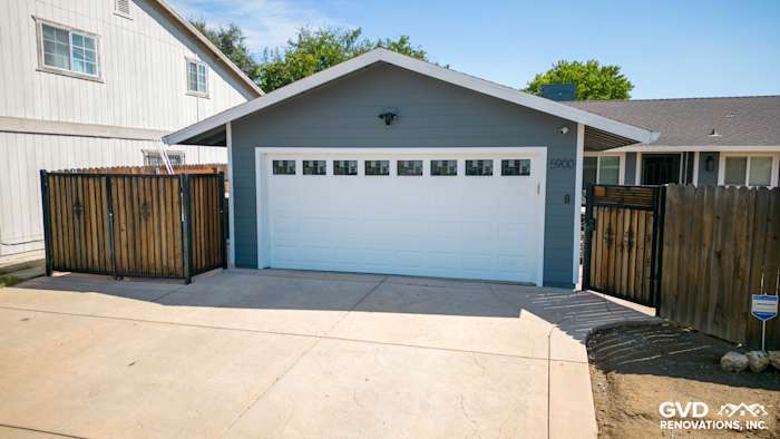 House exterior featuring Night Gray James Hardie lap siding and Arctic White trim, with a garage and fenced driveway