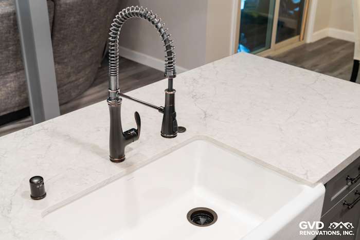 Modern kitchen sink with quartz countertop and sleek black faucet in remodel project