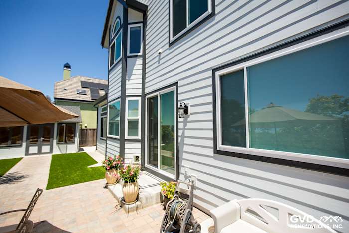 Home exterior in Hayward with Arctic White James Hardie siding and Iron Gray trim, featuring large windows and patio