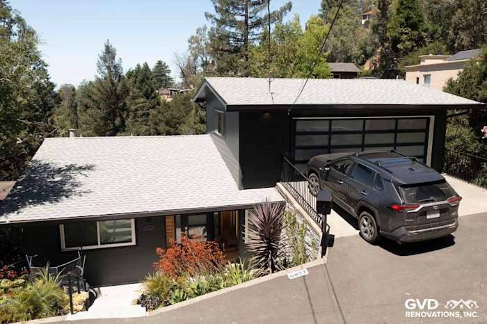 Modern home exterior featuring James Hardie Iron Gray siding, landscaped entryway, and sleek garage design