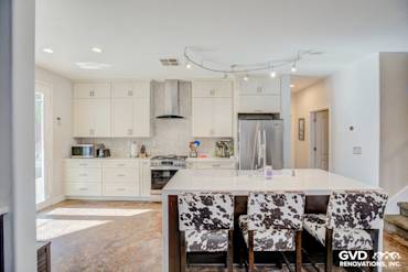 Bright modern kitchen remodel in Roseville featuring white cabinets, quartz island, and cowhide bar stools