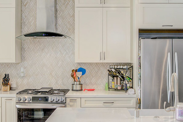 Bright modern kitchen remodel in Roseville featuring white cabinets, quartz island, and cowhide bar stools