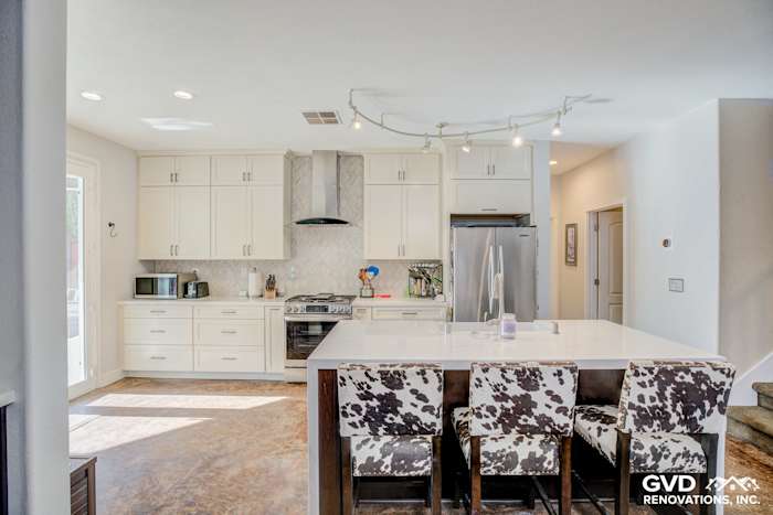 Bright modern kitchen remodel in Roseville featuring white cabinets, quartz island, and cowhide bar stools