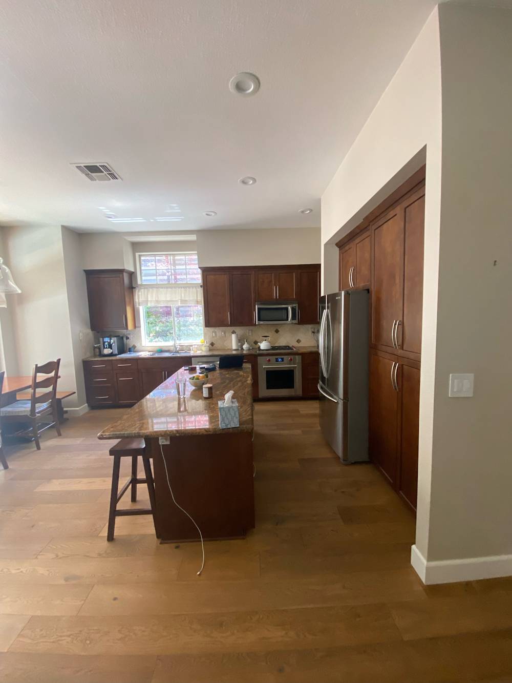 Spacious Sacramento kitchen featuring wooden cabinets, stainless appliances, and hardwood flooring