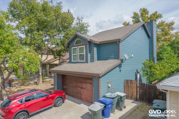 Freshly remodeled two-story home exterior with James Hardie siding in teal, Anlin windows, and brown garage door