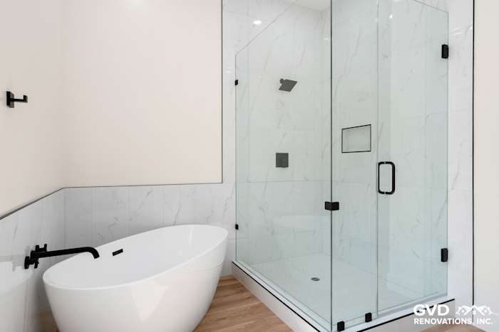 Modern bathroom featuring a freestanding tub, glass shower enclosure, and marble accent walls in Paradise, CA