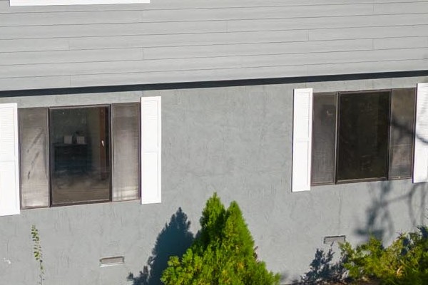 Gray Slate James Hardie lap siding with Arctic White trim on a two-story Colfax home, featuring solar panels and landscaped