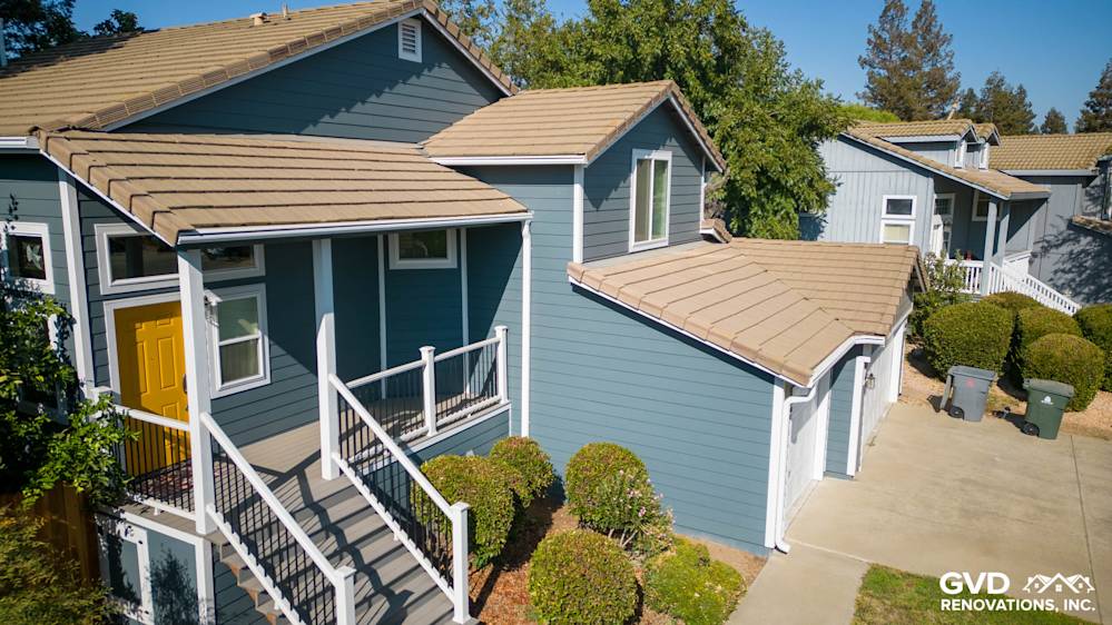 Updated home exterior in Dixon with new blue siding, Anlin windows, and refreshed deck with side steps