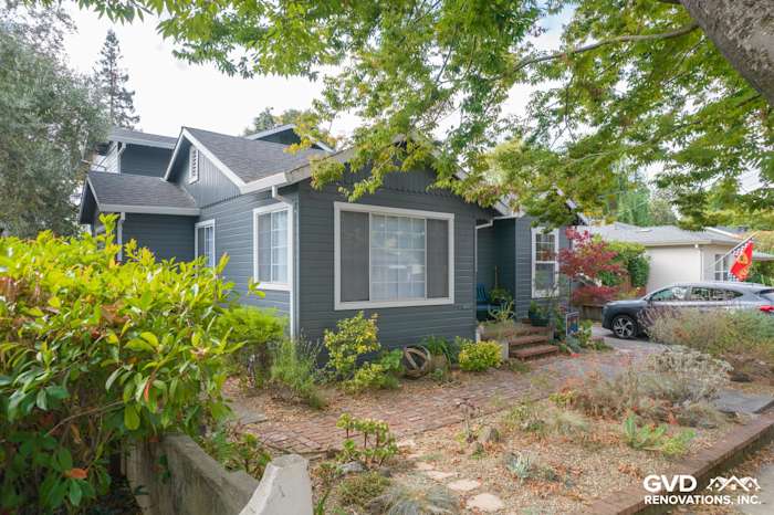 Freshly installed James Hardie Lap siding in deep blue on a Napa home, surrounded by greenery and brick pathway