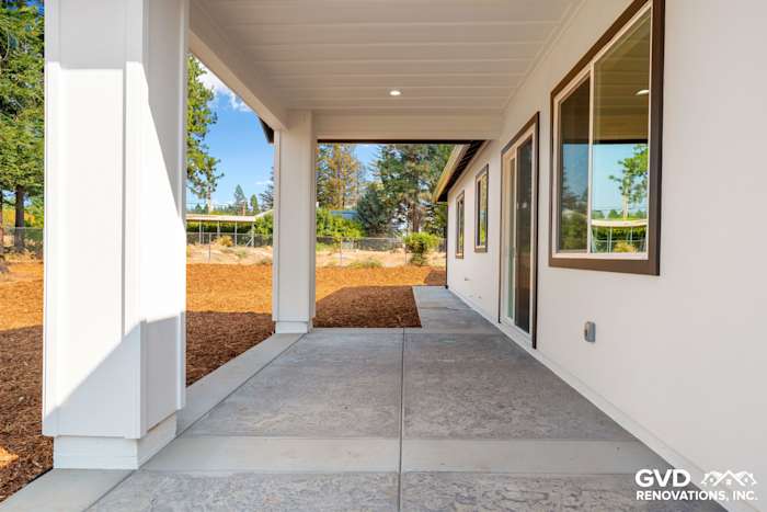 Modern concrete walkway leading to a spacious new construction home in Paradise, CA with large windows
