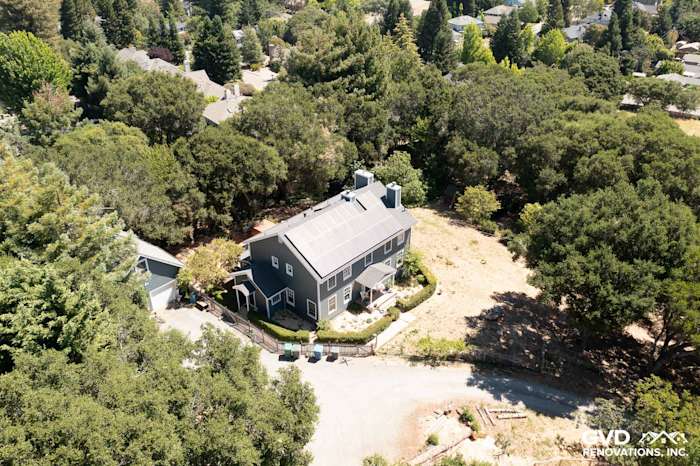 Aerial view of a home with Evening Blue James Hardie lap siding and Arctic White trim in a wooded setting