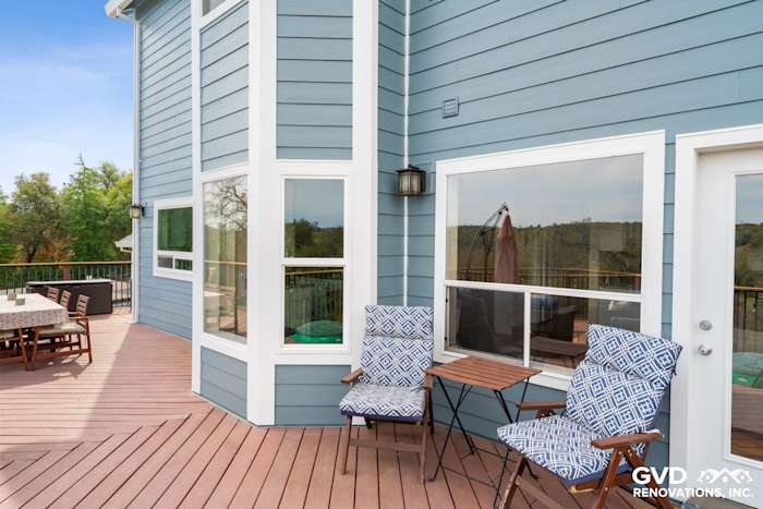 Modern home exterior featuring new blue James Hardie siding and a wooden deck in Shingle Springs, CA
