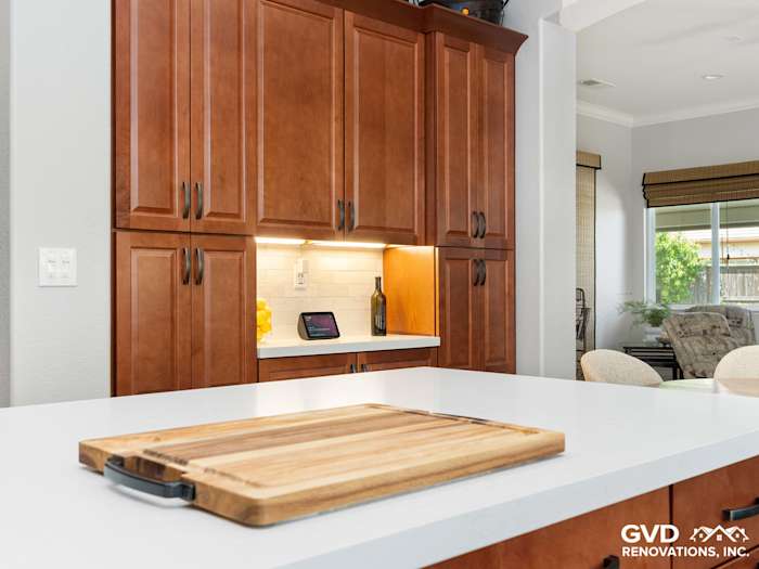 Warm wood cabinets frame a bright kitchen with quartz countertop and modern lighting in Elk Grove remodel