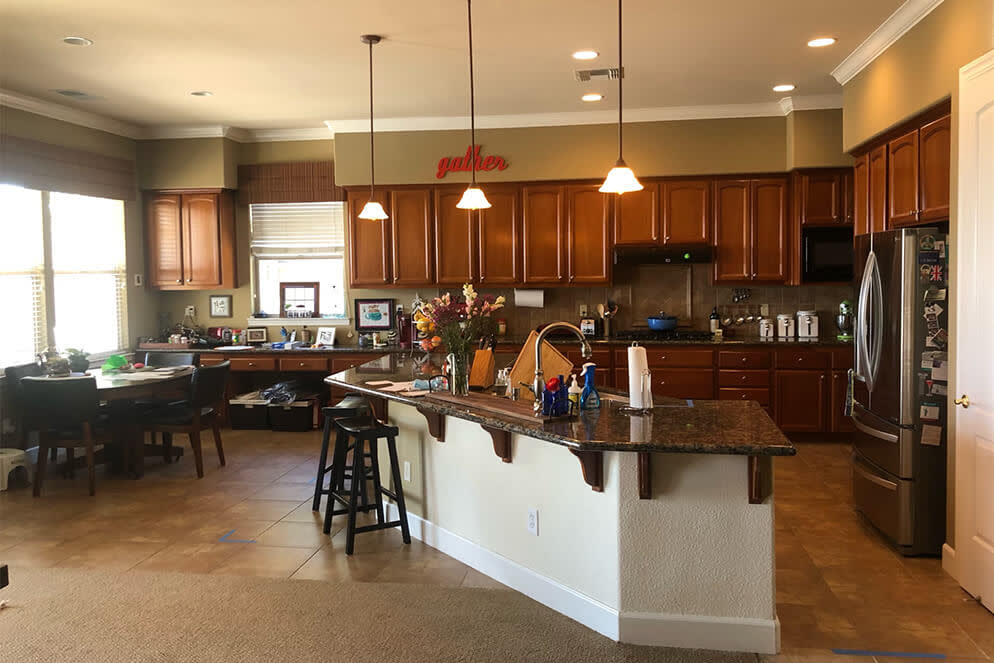 Spacious Sacramento kitchen with wooden cabinets, granite counters, and beige tile flooring