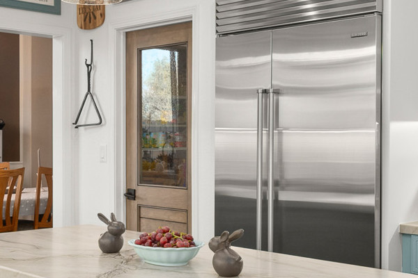 Elegant kitchen remodel in Roseville with blue cabinetry, quartzite countertops, and stainless steel appliances