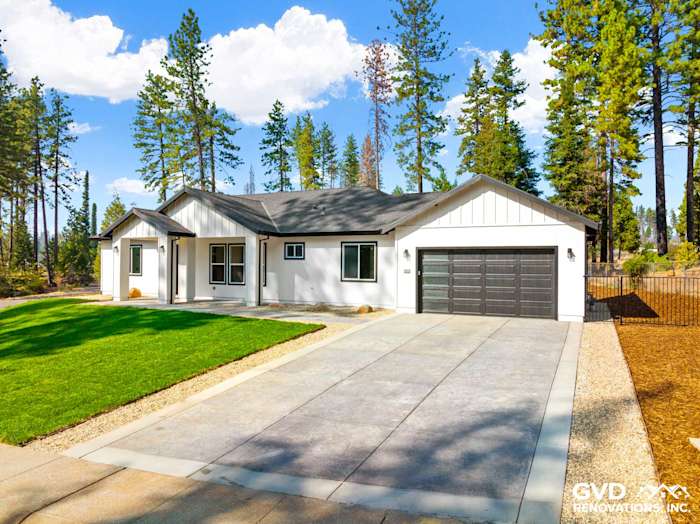 Modern new construction home in Paradise, CA, featuring a gray roof, white siding, and landscaped front yard