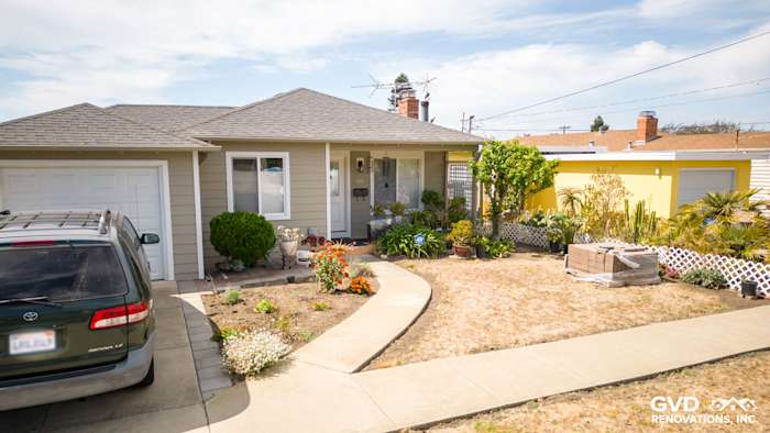 Home exterior in El Cerrito featuring James Hardie Monterey Taupe siding and Arctic White trim, landscaped yard with flowers