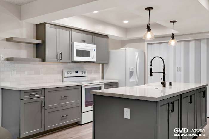 Modern kitchen remodel in Sacramento featuring gray cabinetry, quartz countertops, and stylish pendant lighting