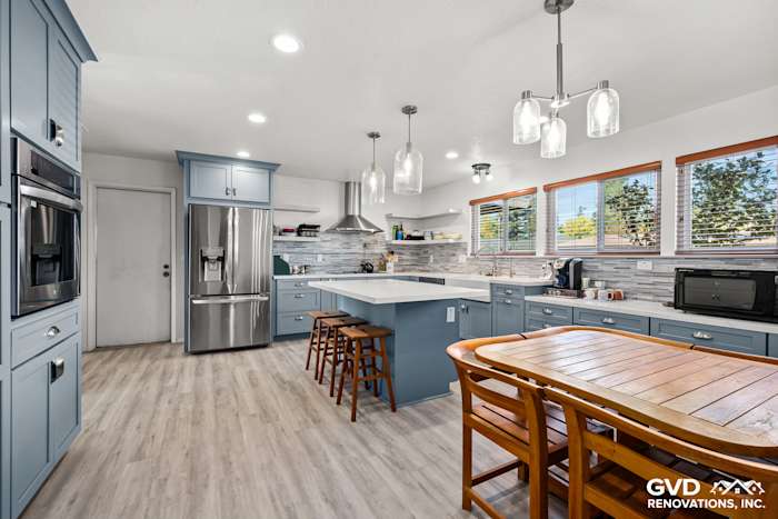 Modern kitchen remodel in Elk Grove featuring blue Waypoint cabinets, quartz countertops, and Misty Fjord backsplash