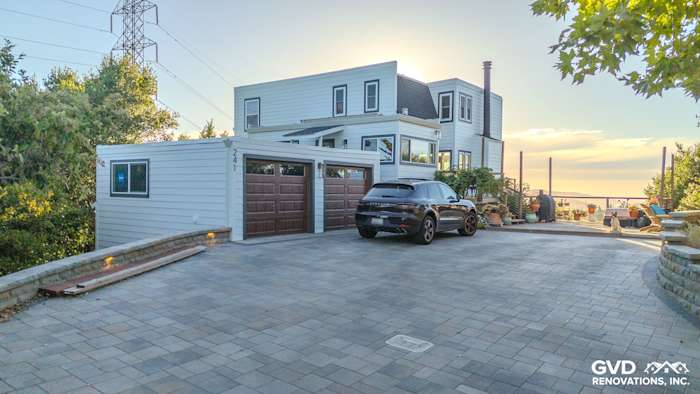 Modern home exterior in Orinda, CA featuring James Hardie Arctic White siding and Anlin windows with a stone driveway