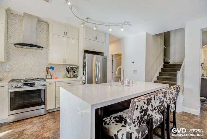 Modern kitchen remodel with white cabinetry, quartz island, and stylish bar seating in Roseville