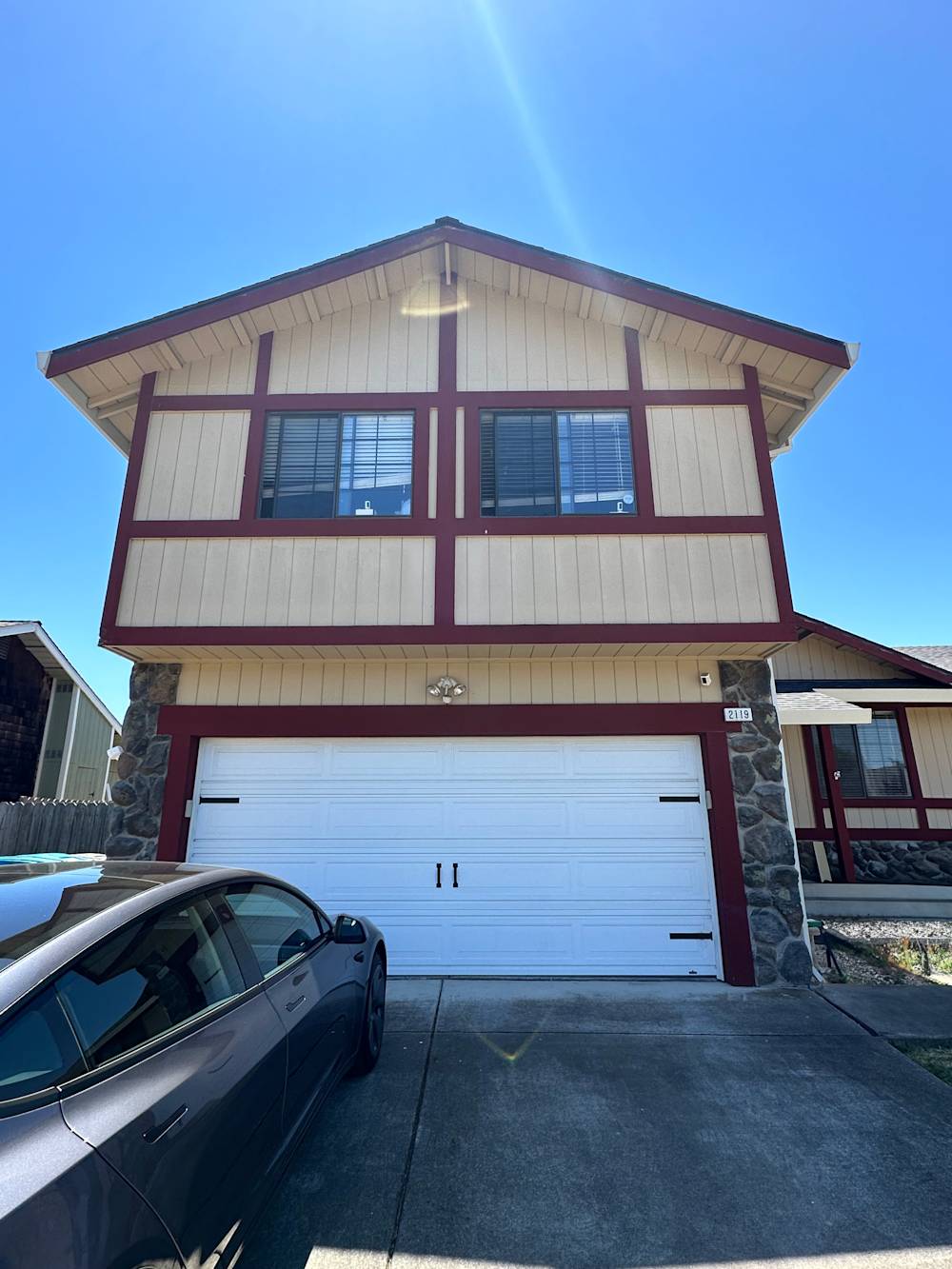 Old two-tone home exterior with yellow siding and red trim, dated appearance