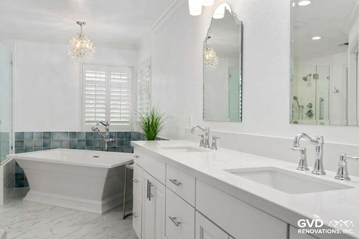Bright, modern bathroom with white cabinetry, quartz countertops, freestanding tub, and blue tile accents in Fair Oaks
