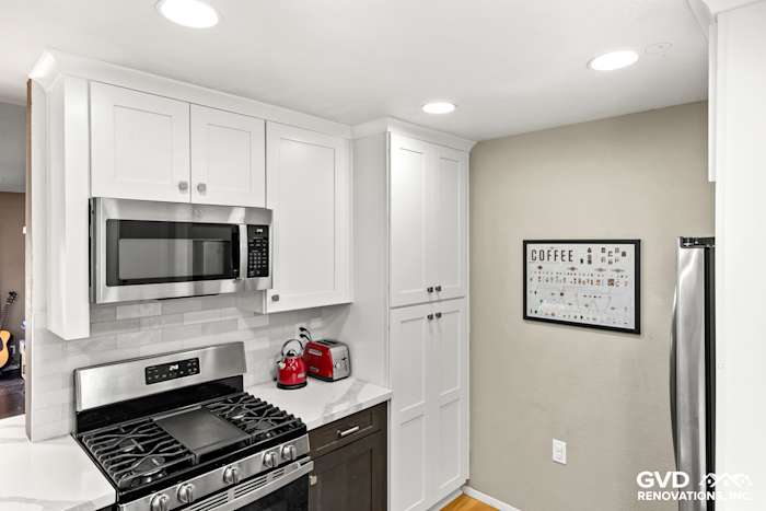 Modern kitchen with white cabinetry, stainless steel appliances, and a gray backsplash in Davis, CA