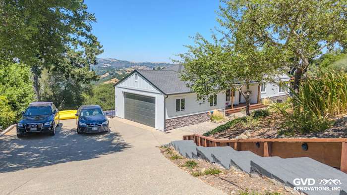 Modern home exterior with James Hardie Artisan and Board and Batten siding, custom Anlin Windows, and rock apron skirting