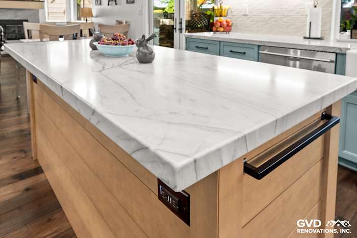 Close-up of MSI Denali White Quartzite countertop on a kitchen island with wood base and sleek black hardware