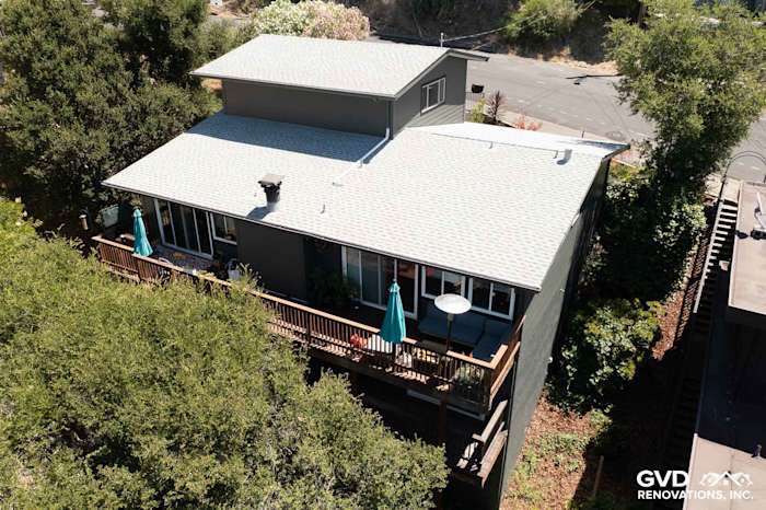 Home exterior featuring James Hardie Iron Gray lap siding and deck with green umbrellas in Oakland, CA