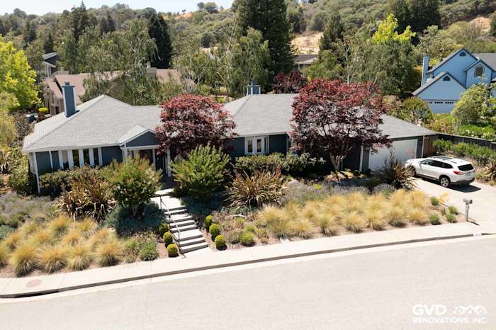 Home exterior in San Rafael, featuring James Hardie Evening Blue lap siding and Arctic White trim, surrounded by lush