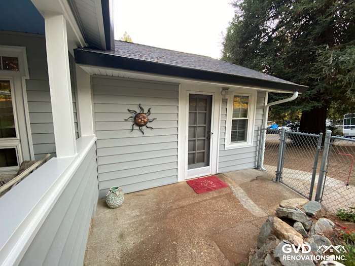 Light gray Prodigy vinyl siding on a home exterior with a decorative sun and entryway door in Grass Valley, CA