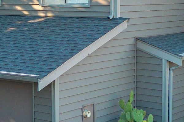 Modern home exterior featuring Alside Prodigy Vinyl siding in Ageless Slate, with lush landscaping in Hayward