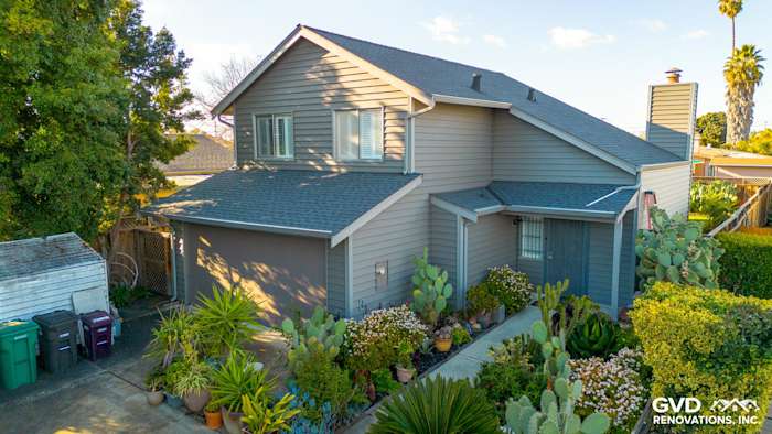 Modern home exterior featuring Alside Prodigy Vinyl siding in Ageless Slate, with lush landscaping in Hayward