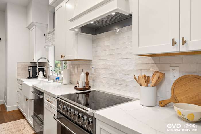 Modern kitchen in Folsom featuring white Waypoint cabinets, Vadara Bronzo countertops, and stylish backsplash tiles