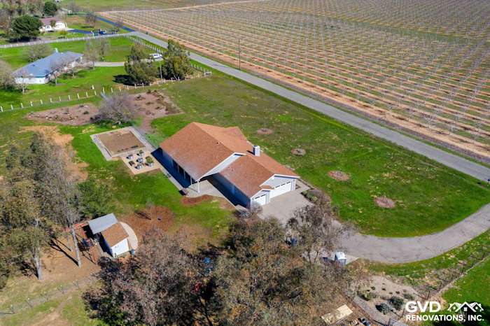 Aerial view of a home with Pearl Gray James Hardie Siding and Anlin Windows, surrounded by green fields in Galt, CA