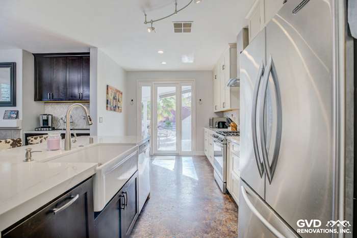 Bright modern kitchen featuring stainless steel appliances, quartz countertops, and open space with access to outdoor area